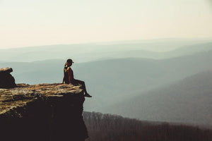 Lady sitting on edge of a cliff