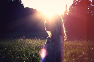 Woman in field at sunrise