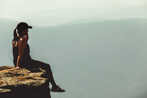 Woman sitting on edge of a cliff